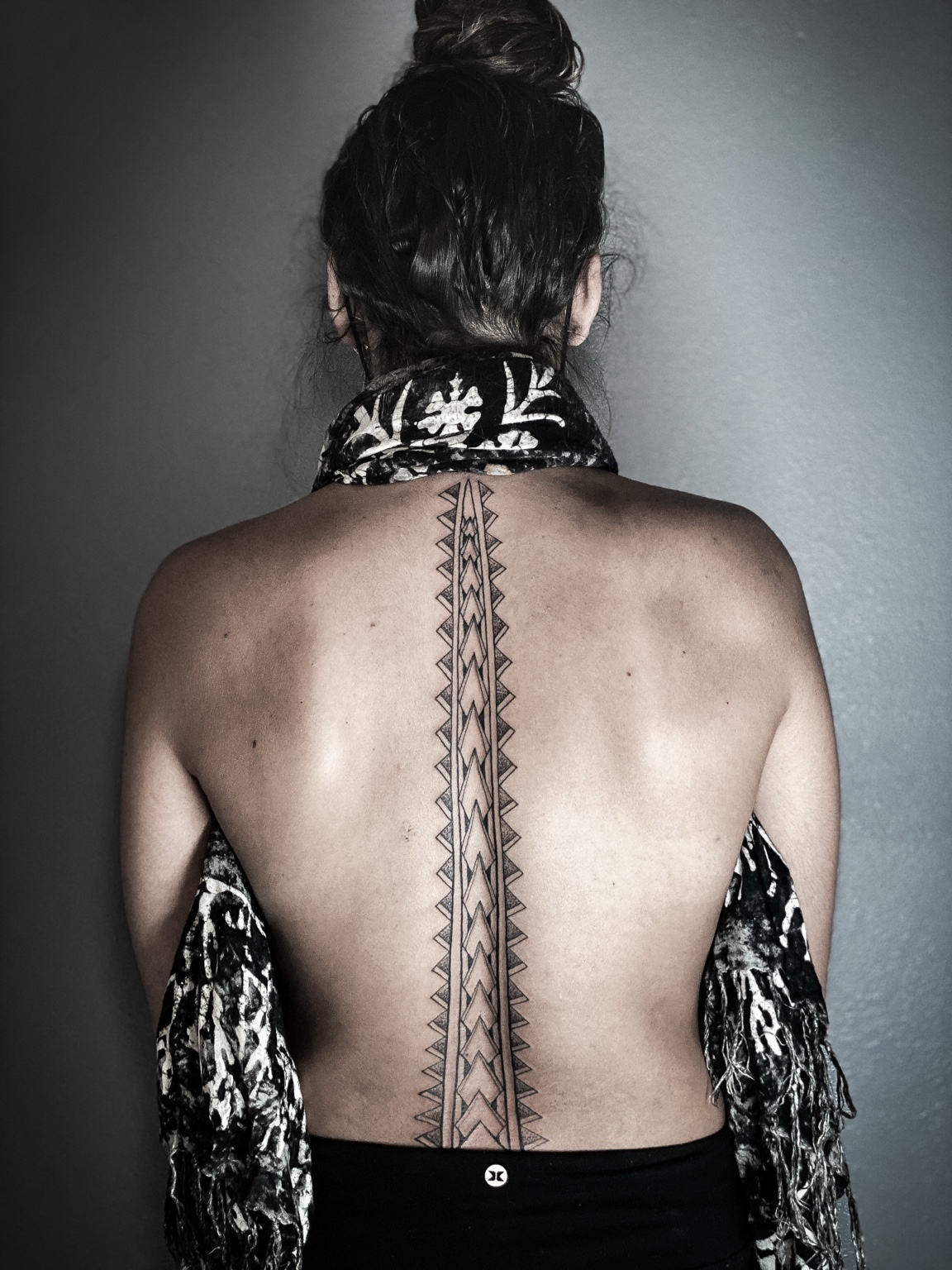 Fine-line spine tattoo by Kai