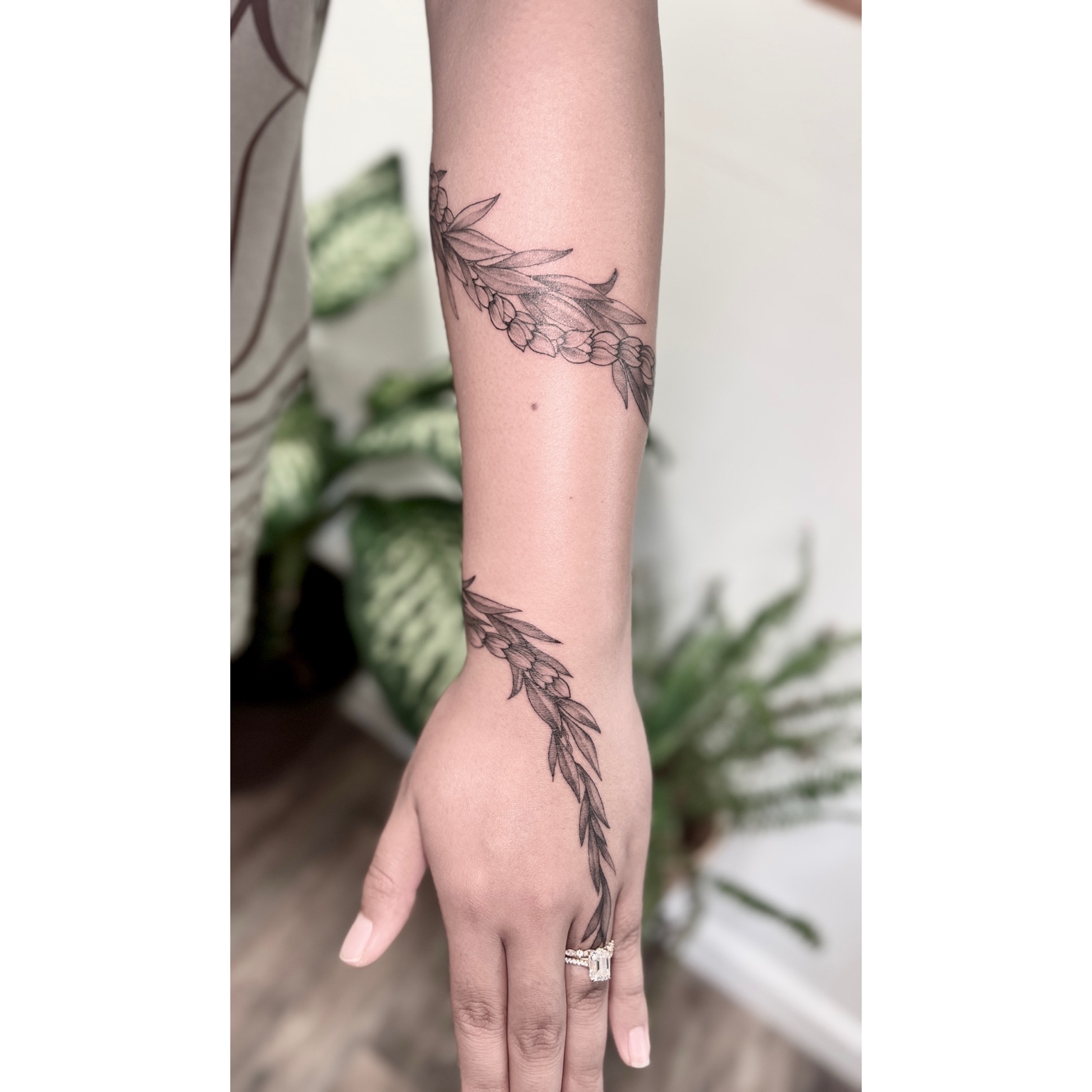 Fine-line botanical hand tattoo by Kai