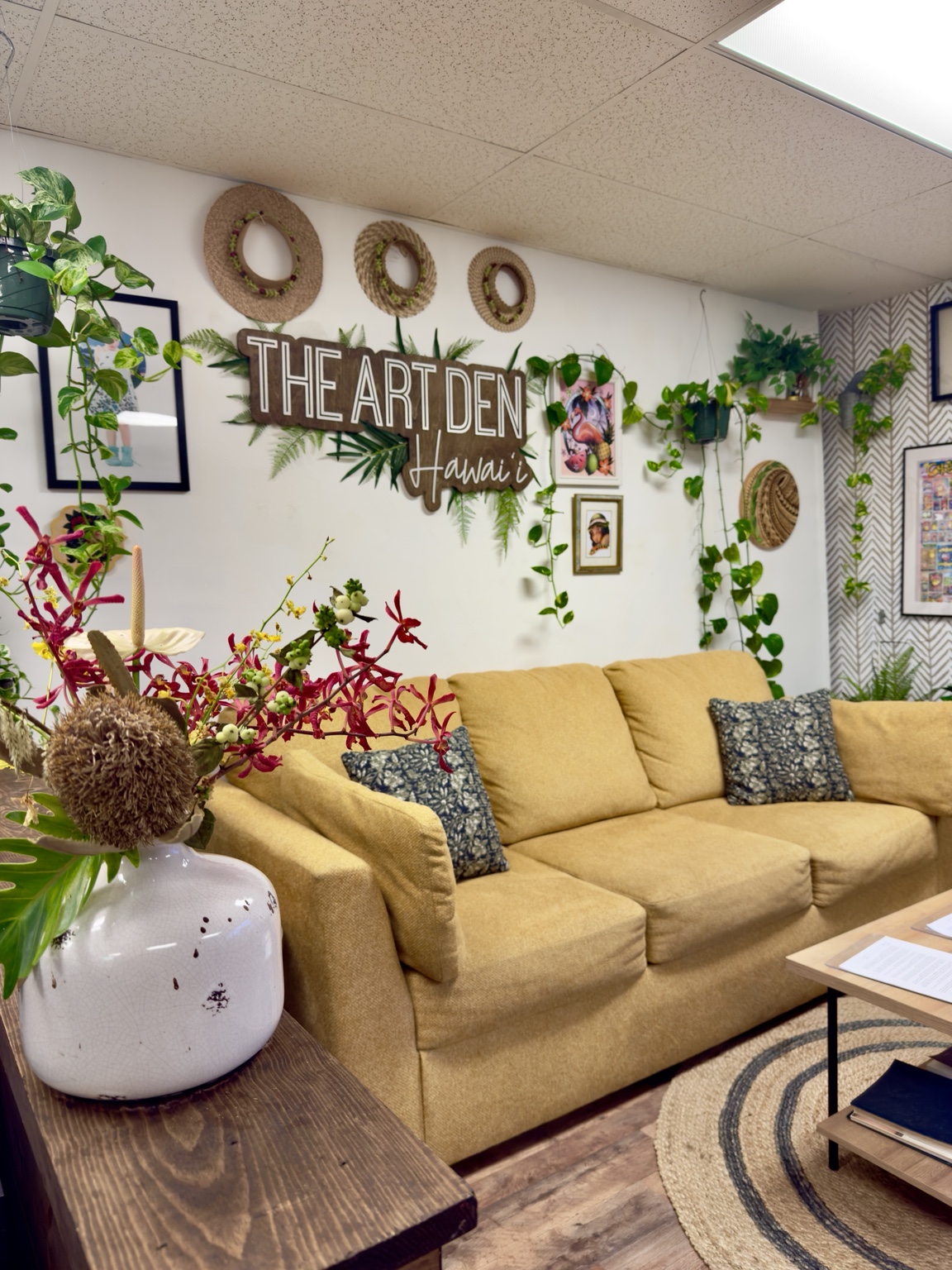 Warm, plant-filled lounge inside The Art Den Hawaiʻi